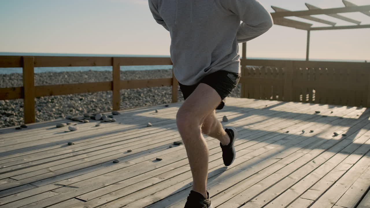 hombre estirándose en una cubierta de madera en la playa