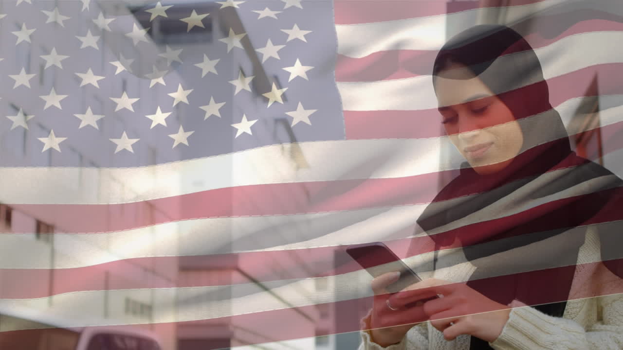 animación de la bandera estadounidense ondeando sobre una mujer biracial en hijab usando un teléfono inteligente