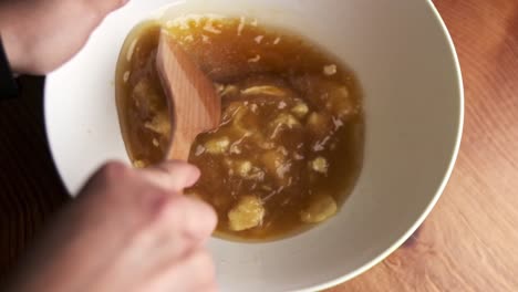 Mixing-ingredients-with-a-wooden-spoon-to-make-chocolate-chip-cookies