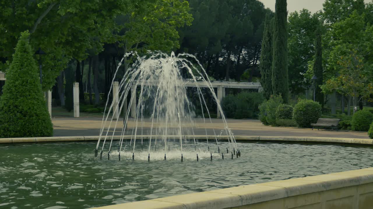 una fuente de chorros de agua en arco en un parque