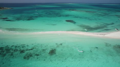 aerial view of kitesurfers in turquoise water near a sandbar