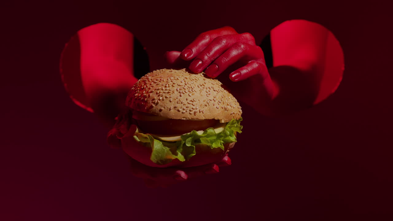 cerca de una sabrosa hamburguesa con queso en las manos rojas de una hermosa mujer.