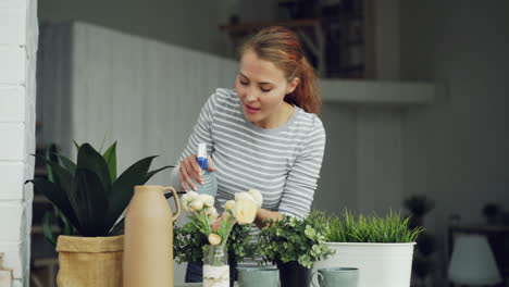 woman watering houseplants and flowers at home