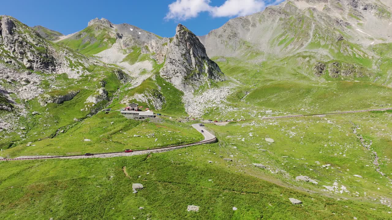 Great St Bernard Pass crossing lush Swiss mountains under bright summer sky, 4K