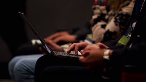 people with laptops sitting in corporate event, wearing business clothes