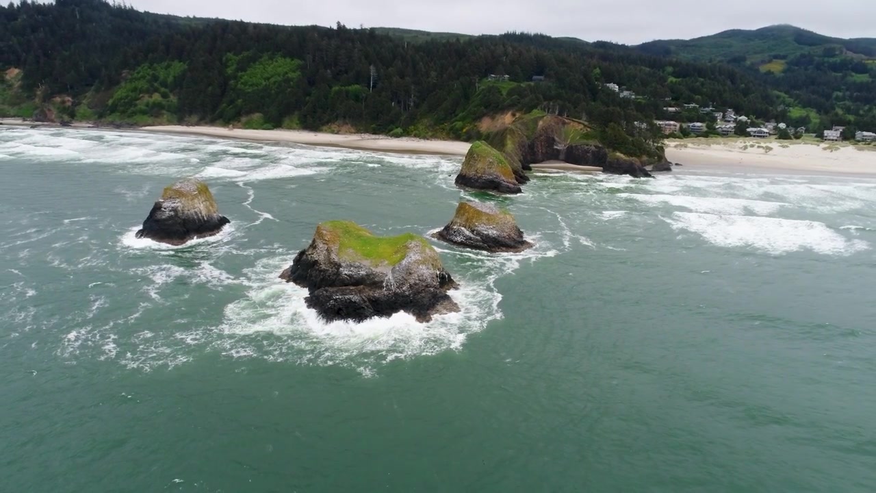 Un drone cinematografico ad alta quota si allontana molto sull'oceano, mentre riprende i faraglioni chiamati "Bird Rocks" e il sito naturale statale John Yeon, a nord di Chapman Beach, che si estende lungo la costa frastagliata dell'Oregon.