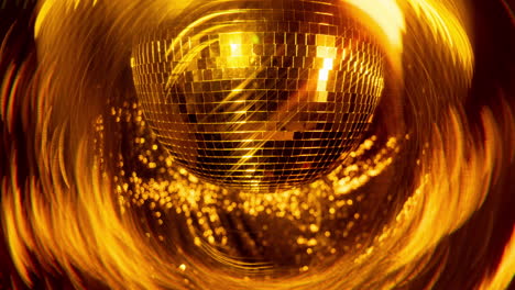 a spinning gold mirror ball in night club