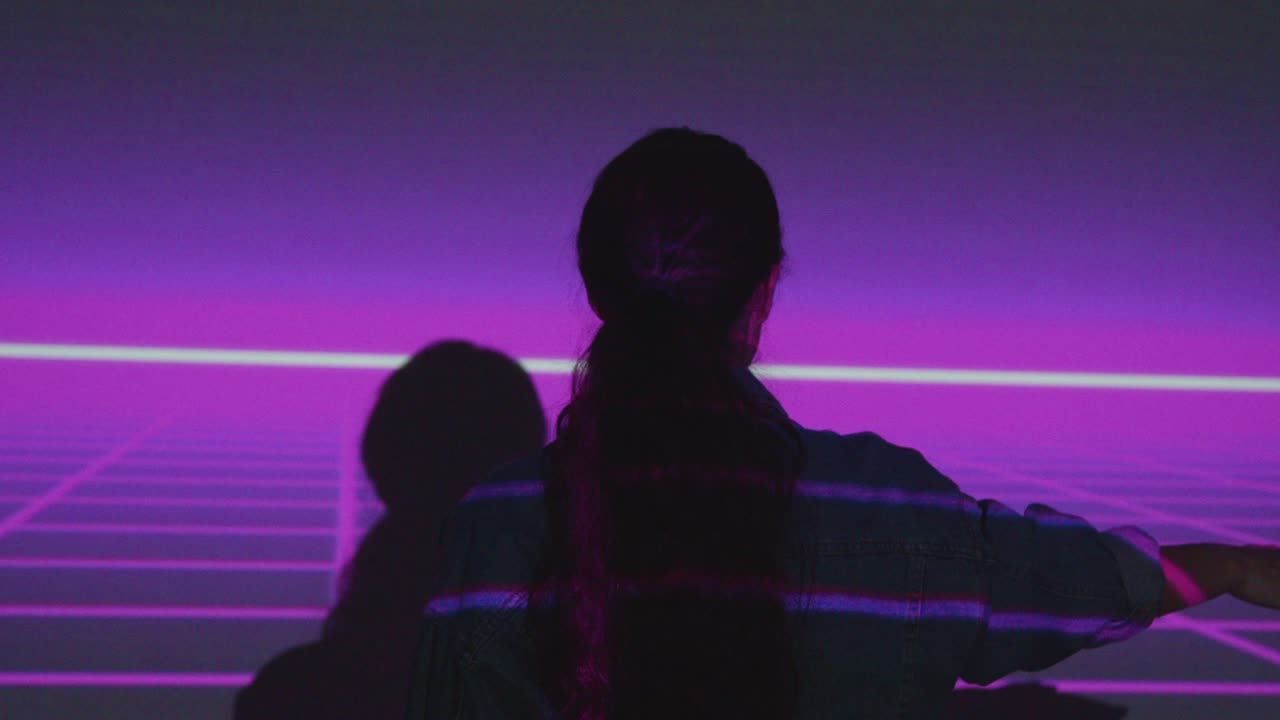 силуэт женщины, посещающей выставку иммерсивного искусства с проекцией сетки на стене