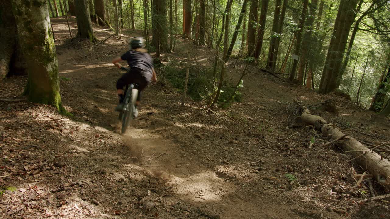 ciclista de montaña aterriza de un salto y recorre un rincón polvoriento
