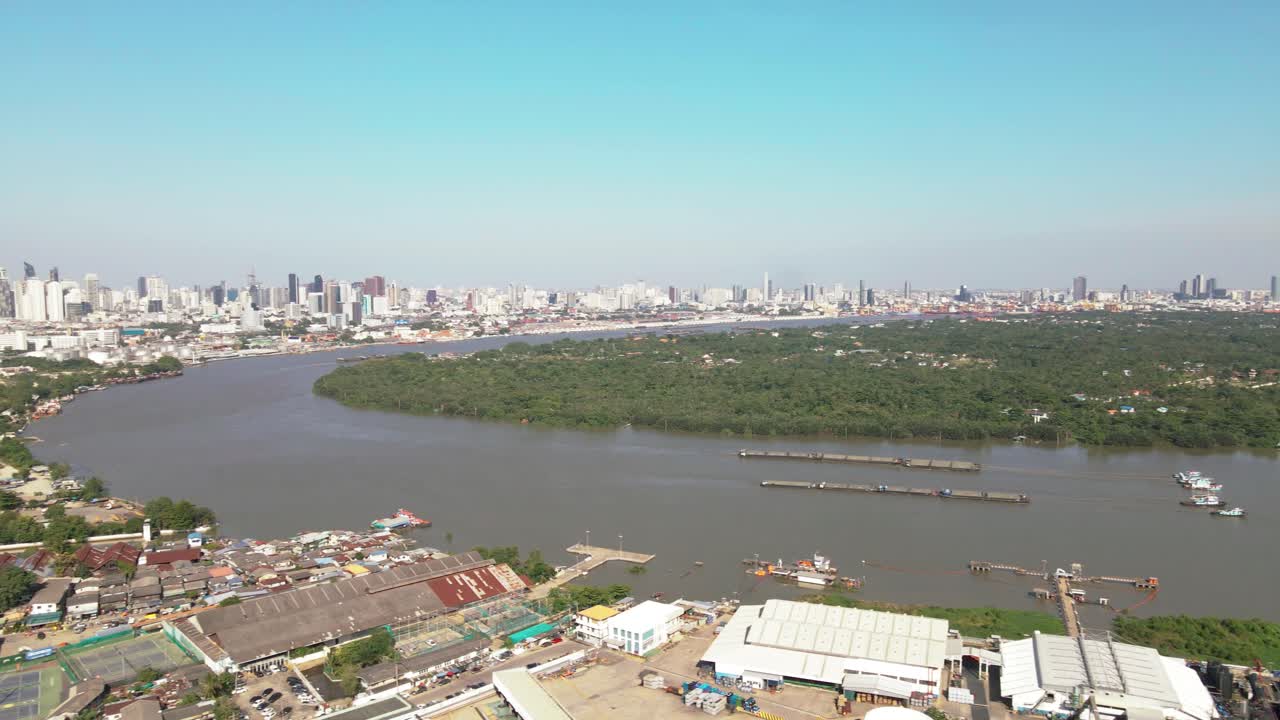 Aerial view of Bangkok skyline over a lush river and industrial area