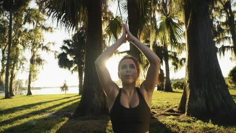 hermoso joven adulto despertándose para una sesión de yoga al aire libre temprano en la mañana y estirándose