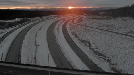 sunrise over icy roads and highways during winter - aerial pullback