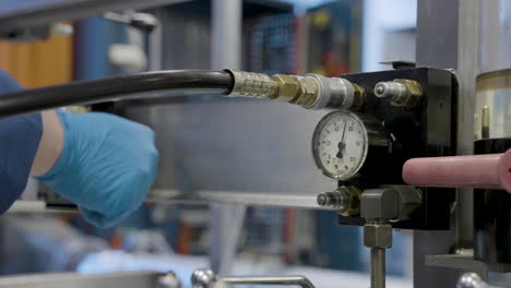 profesor girando el colador para limitar el flujo de aceite y aumentar la presión de aceite que se muestra en el medidor de calibre