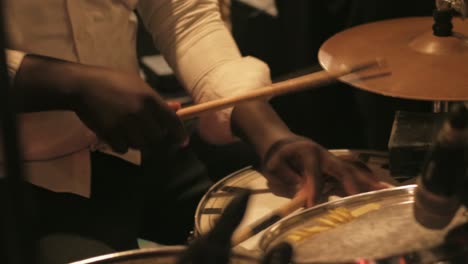 black african man playing drum kit in slow motion at a party in ghana