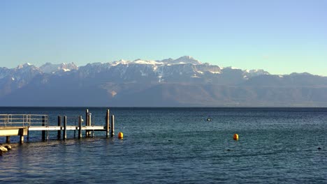 lausana, un embarcadero en el lago de ginebra con los alpes al fondo
