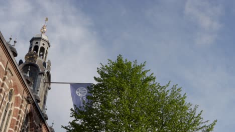 Flag of Leiden University in the Netherlands waving on the historic Academy Building on a sunny morning