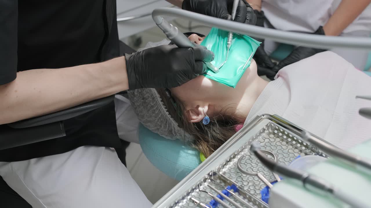 Overview of dental caries prevention, Girl at the dentist chair during a dental scaling procedure,