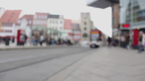 Blurry-people-moving-in-downtown-Erfurt,-historic-city-in-Germany