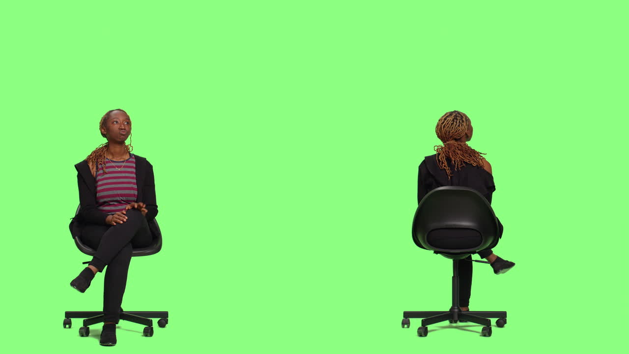 Woman sitting in a chair in front of a green screen