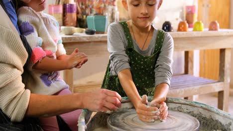 Mother-assisting-her-daughter-in-making-a-bowl