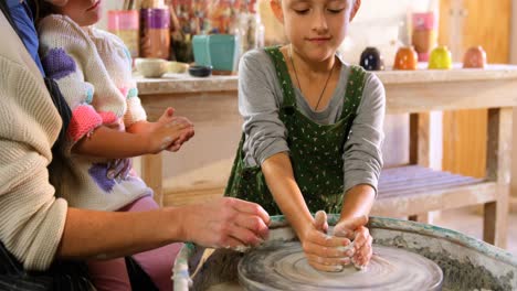 mother assisting her daughter in making a bowl