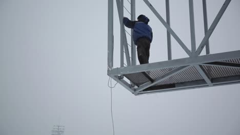 worker climbing metal structure in winter