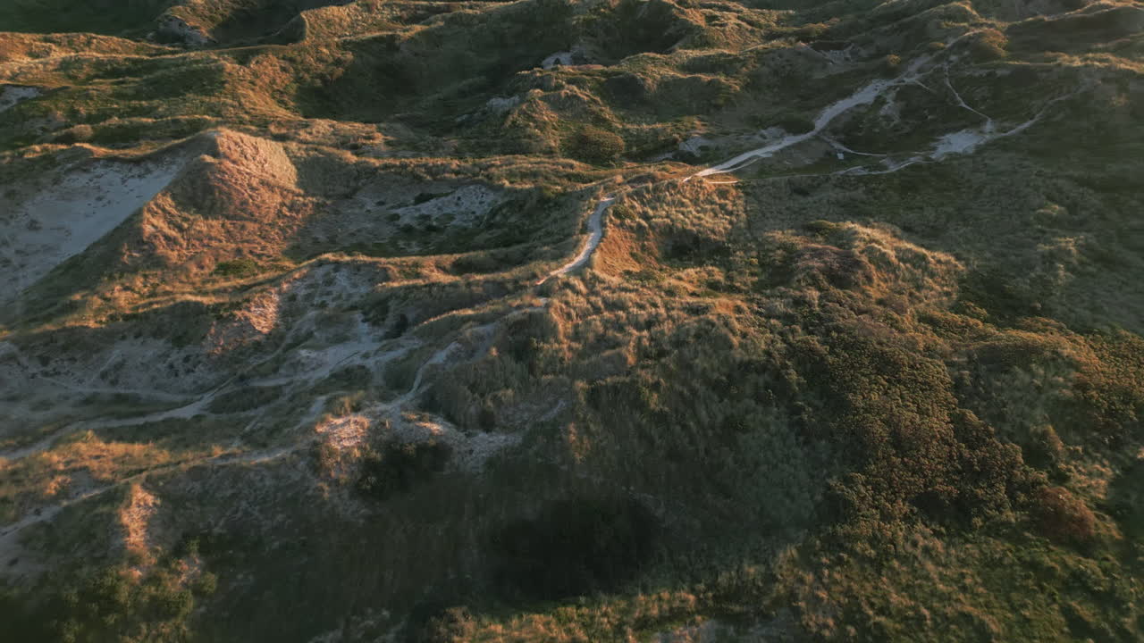 Sunset trails on Denmark's dune landscape, casting long shadows