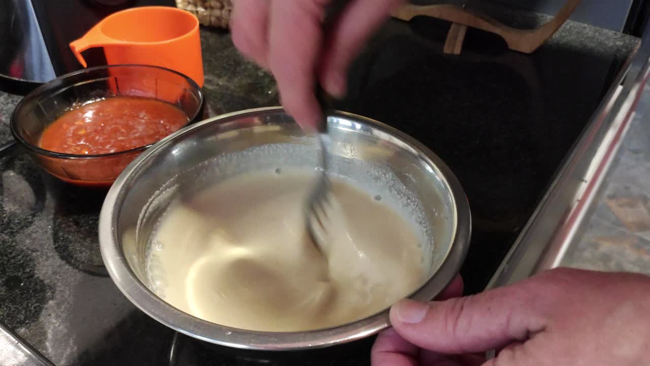 mujer blanca golpeando mezcla en la cocina
