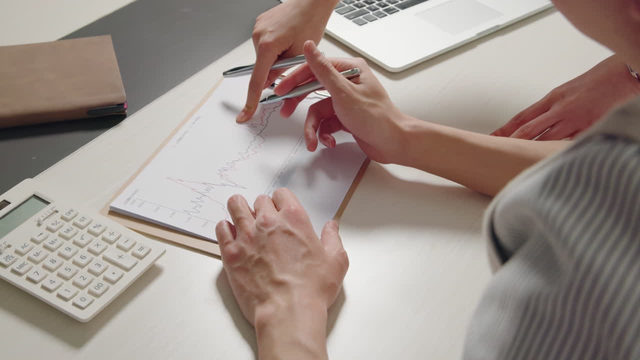 Professional financial advisor discussing investment portfolio, planning and analyzing strategies with client in a modern well lit office setting Guidance Meeting