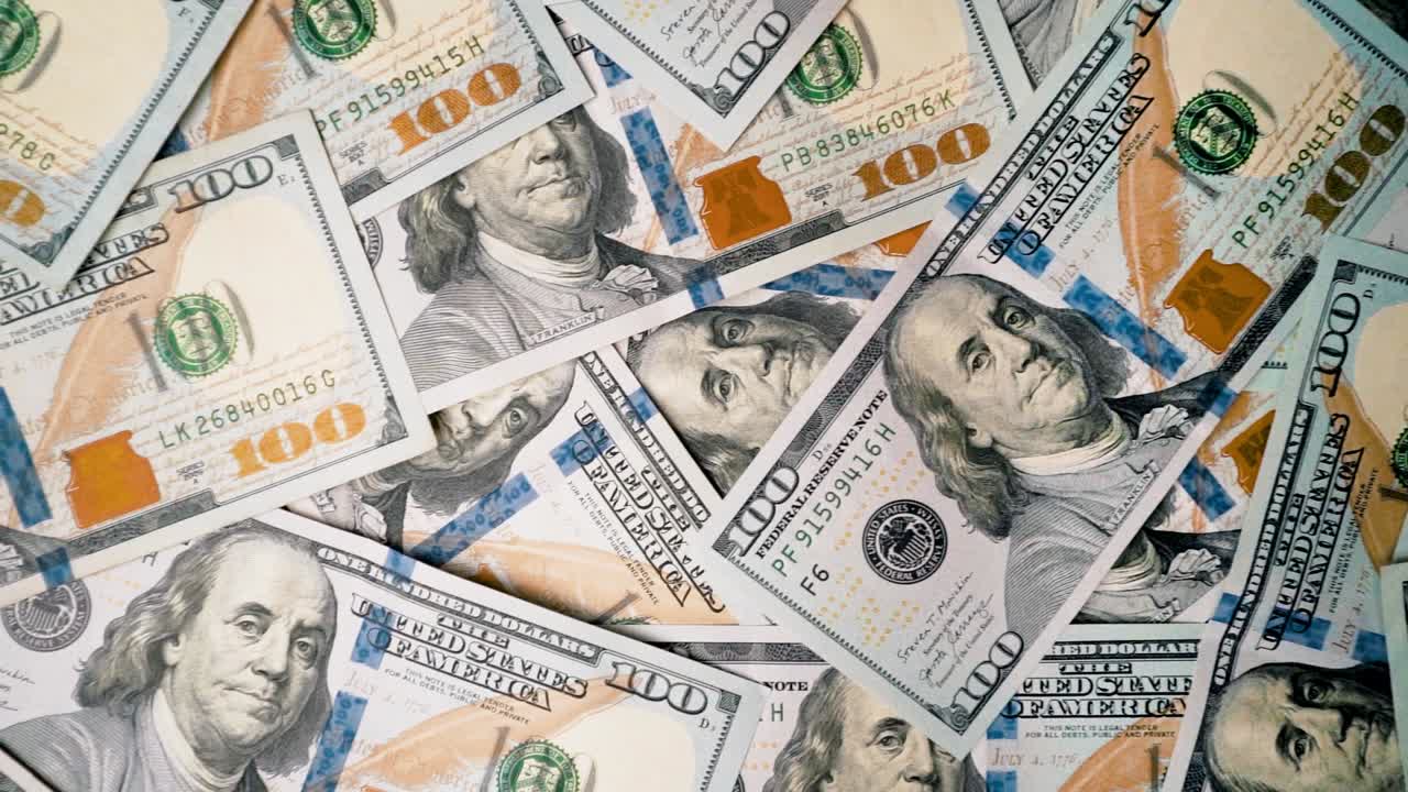 Billetes de cien dólares esparcidos sobre una superficie