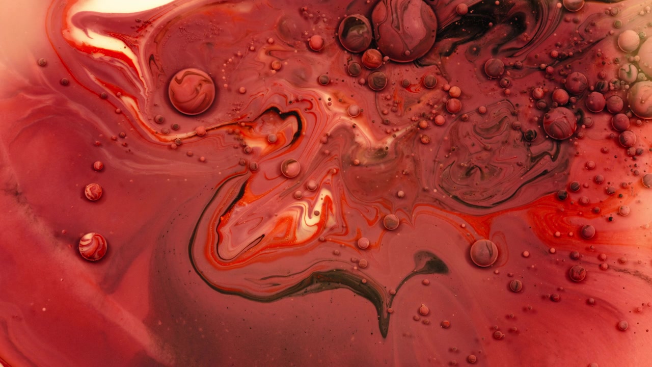 Colori acrilici rossi che si muovono nel liquido