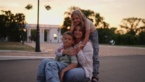 madre e hijos posando al atardecer en un parque