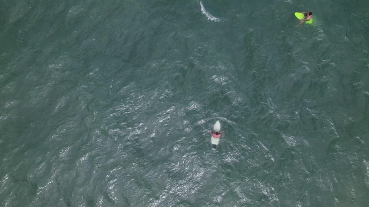 vista superior de un dron que muestra a los surfistas esperando olas