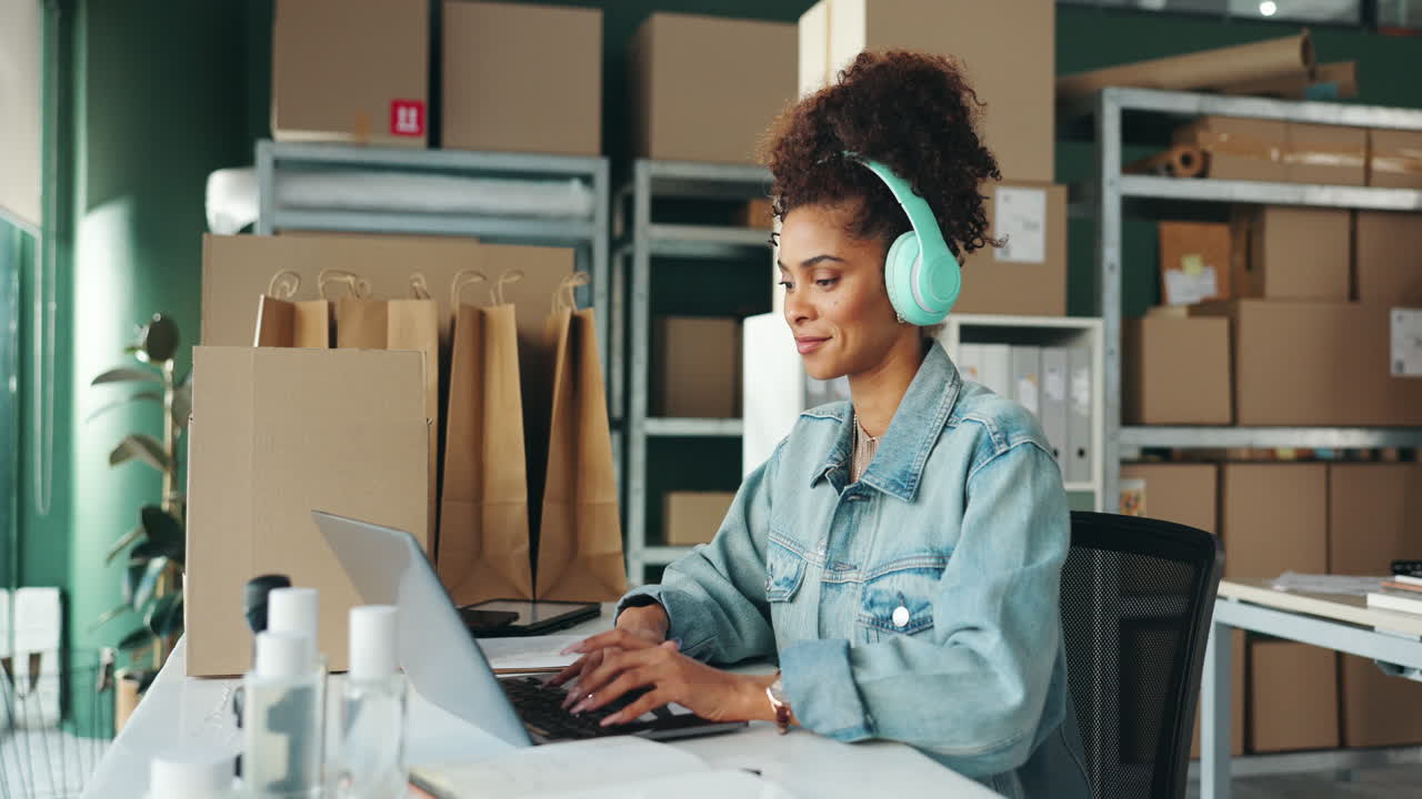 Woman working on laptop in office with boxes and shopping bags