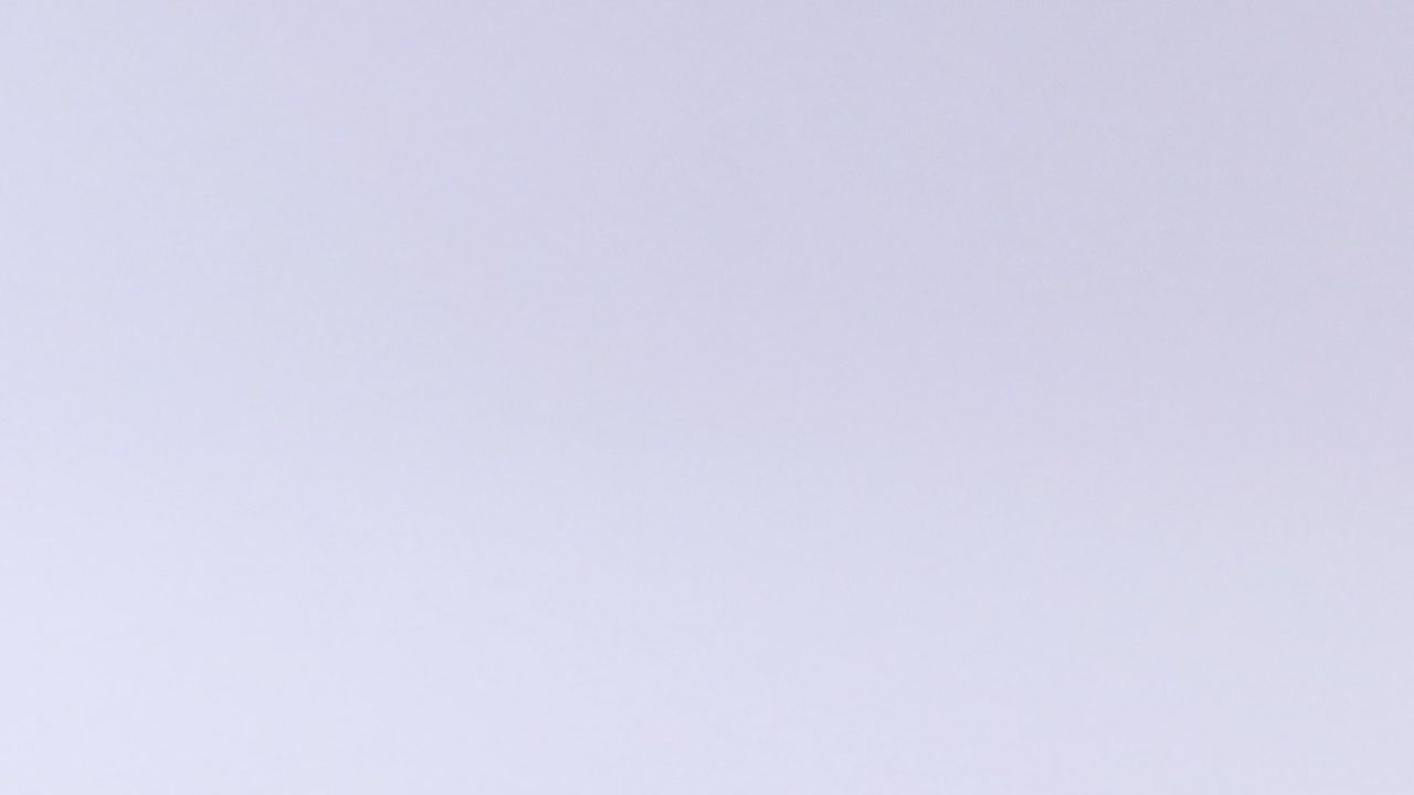 A pink tennis ball moves across a smooth, white background in various positions.