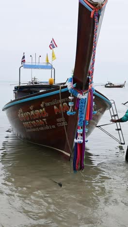 person interacts with boat on krabi beach