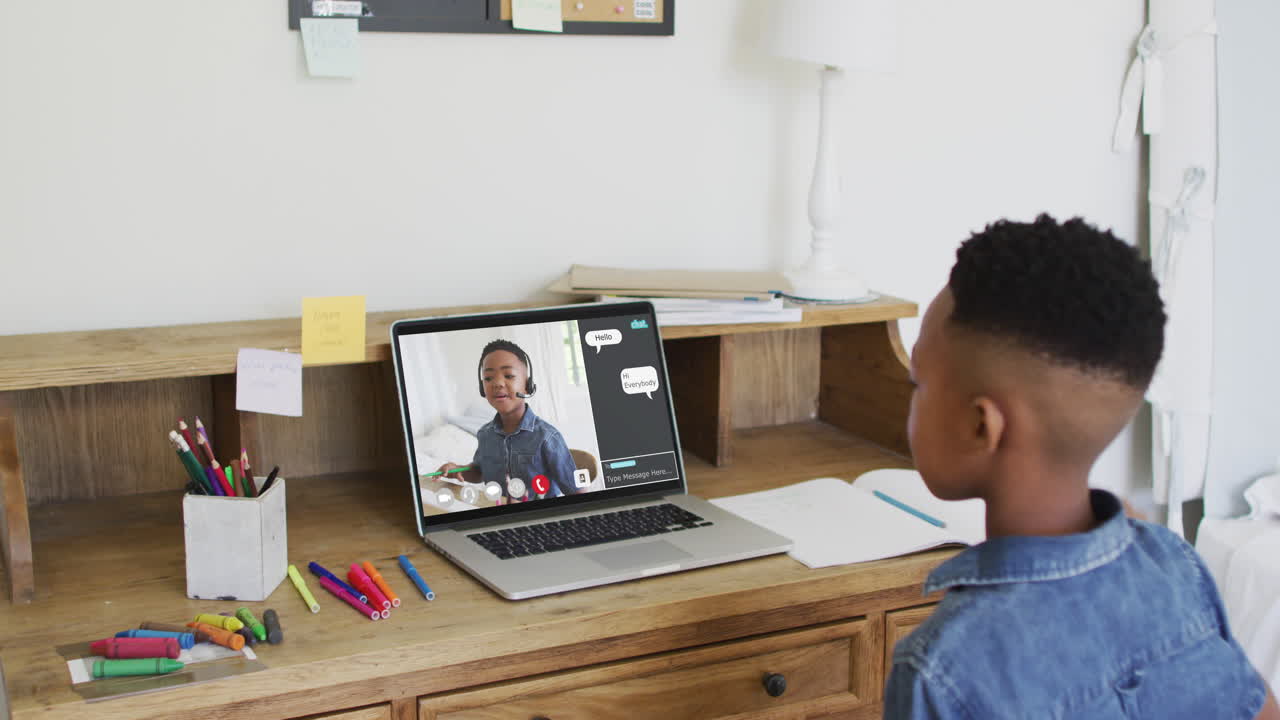 Composite video of boy using laptop raising hand in online lesson, with interface and boy on screen