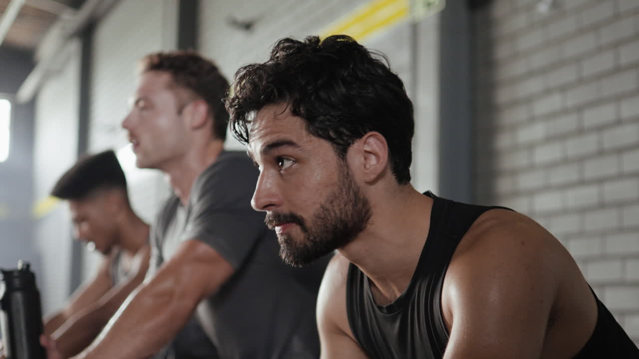 체육관 에서 스핀 자전거 를 타고 운동 하는 남자 들