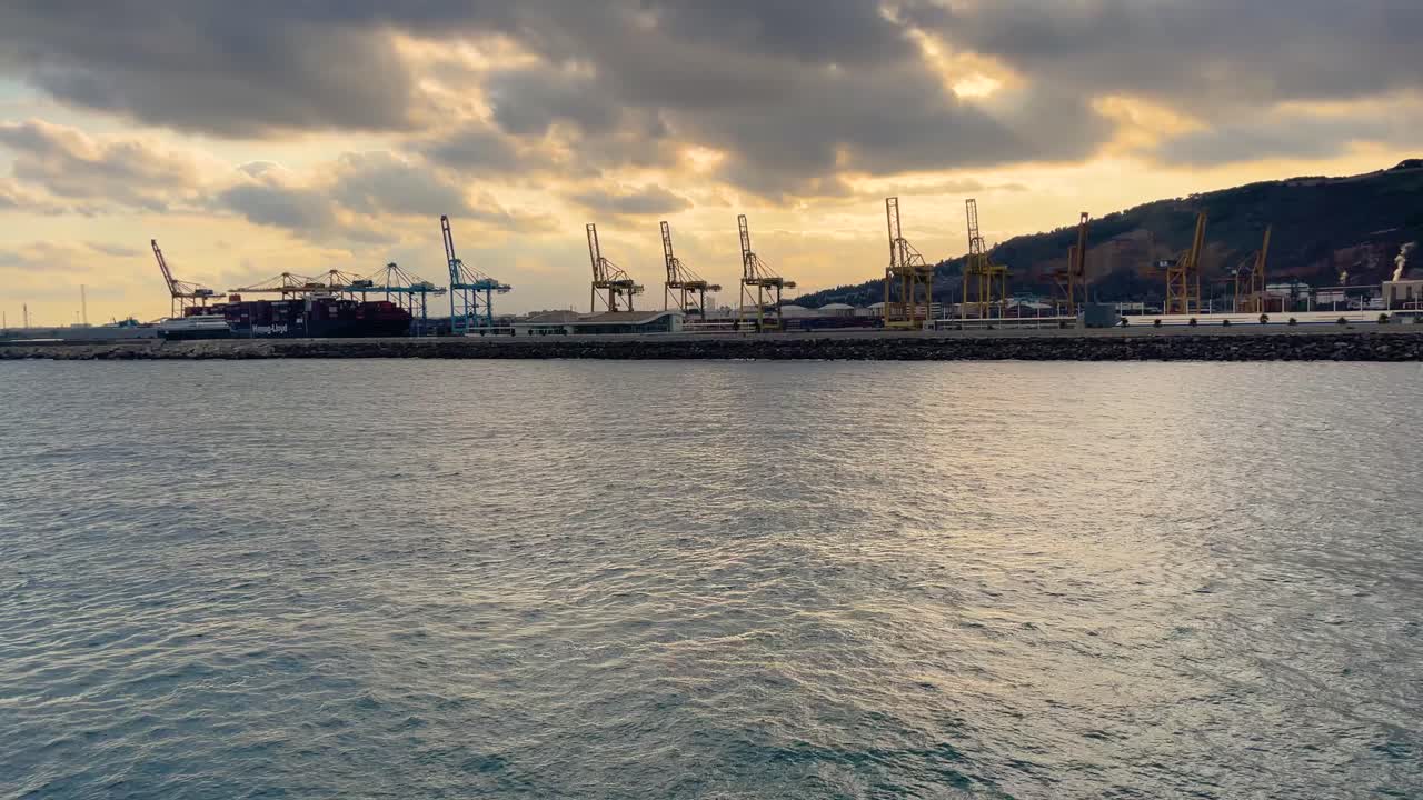 선셋 스카이라인 타워와 컨테이너 선을 적재하는 크레인 여객 페리의 바르셀로나 항구