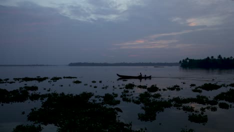 Silhouette-of-boat-and-fisherman-in-backwaters-crossing-,-Steady-Shot
