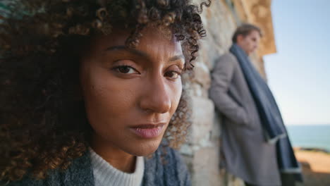 curly brunette looking camera at abandoned place portrait. diverse pair posing