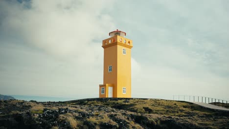 Handheld-shot-of-a-beautiful-yellow-lighthouse-amidst-rocky-terrain