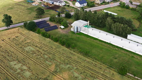 poultry farm with white-roofed and vents near the rural village. - aerial shot