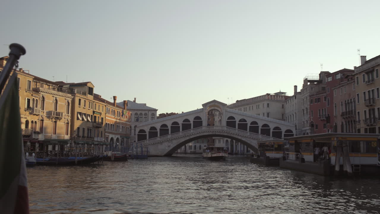 Ampia inquadratura della bandiera italiana e del Ponte di Rialto al mattino senza persone, Venezia, Italia.