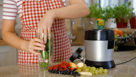 Woman-putting-fruits-in-the-mixer