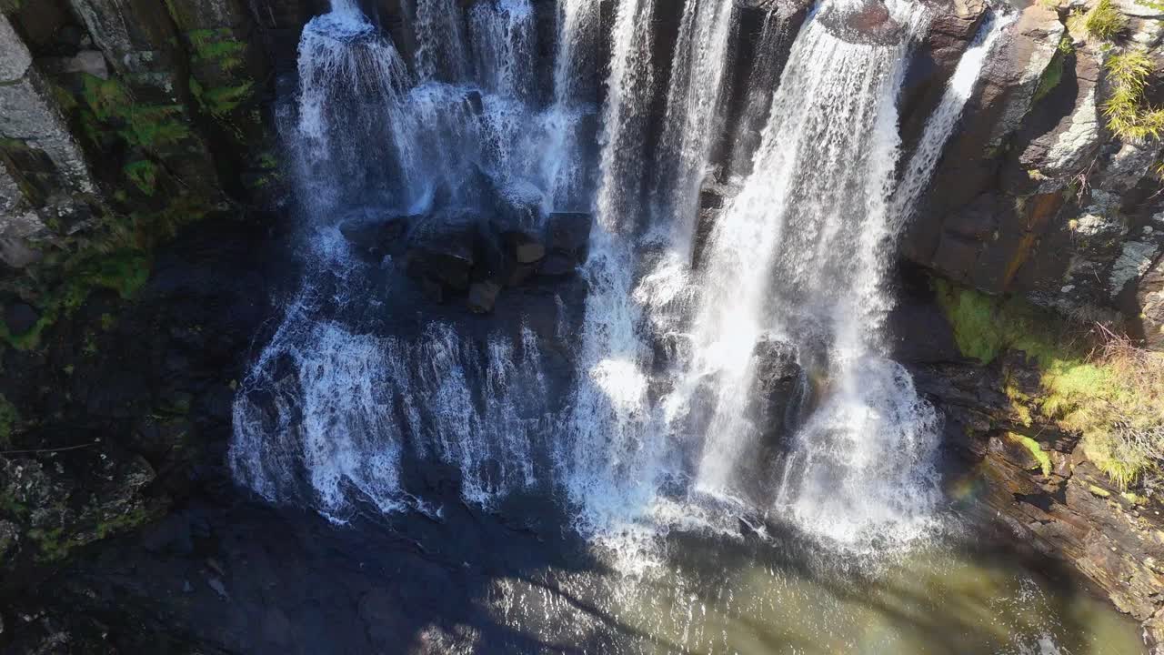 Aerial view of cascading waterfall in lush natural setting