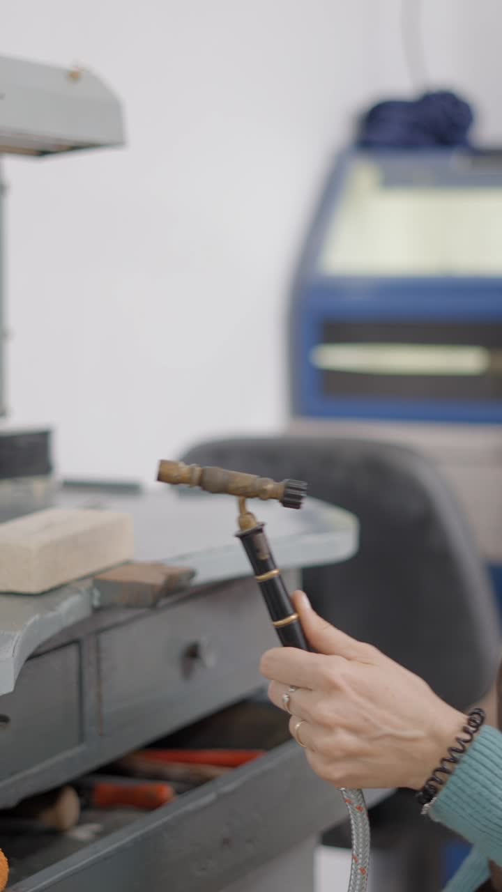 A woman making jewelry in a workshop
