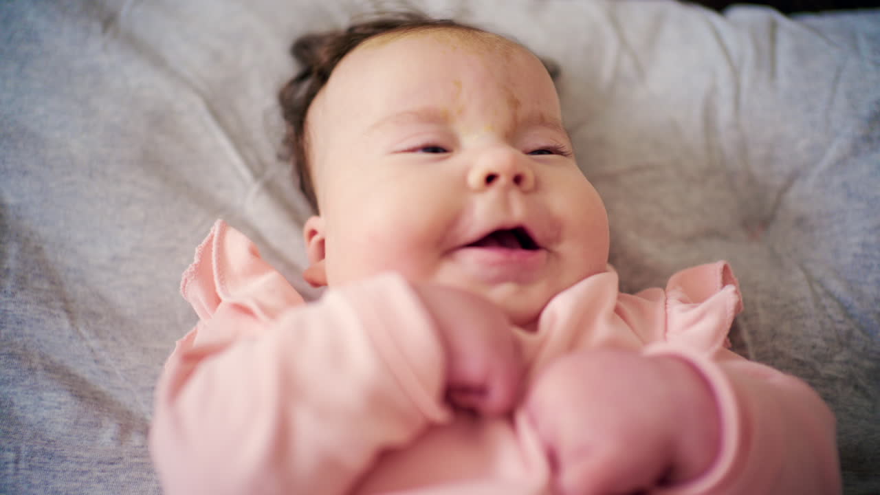 Close up of a newborn baby's feet gently moving while lying on a soft bed