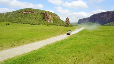 aerial of a 4 wd safari jeep driving in hell's gate national park rift valley kenya africa