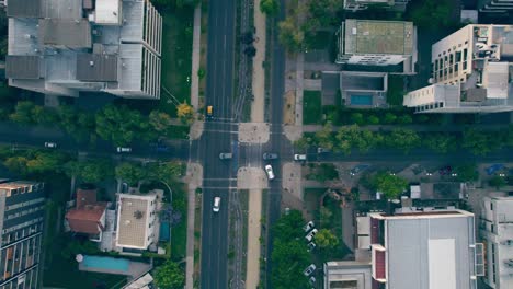 Overhead-aerial-view-of-a-crossroads,-cars-moving-along-the-track